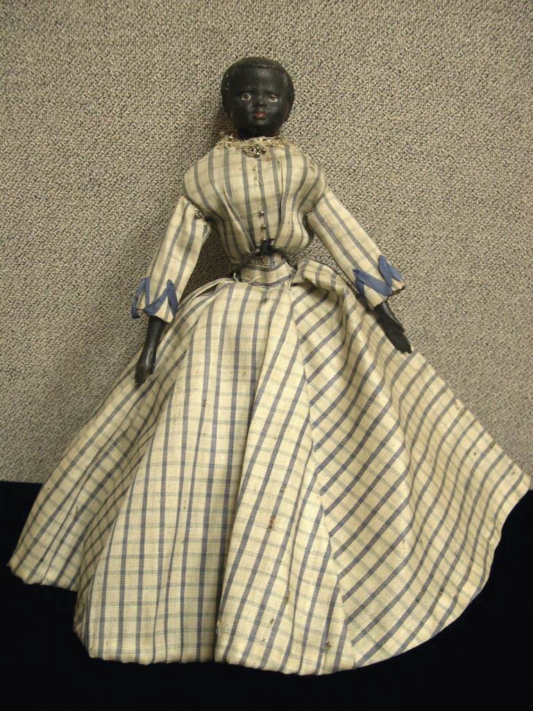 Black composition shoulder head doll: Black composition shoulder head doll, jointed wooden arms and legs, painted facial features. Antique dress. Circa 1910 Height: 11 inches Conditon: some age wear