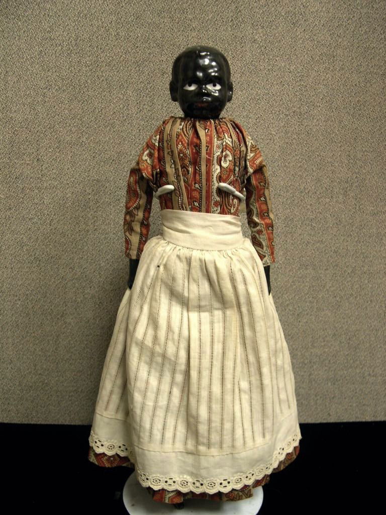 Circa 1880 German black porcelain doll: German black porcelain shoulder head doll, black molded and painted hair, painted facial features. Antique cloth body , porcelain arms and legs. Antique dress and under garments. China boots. Outfit h