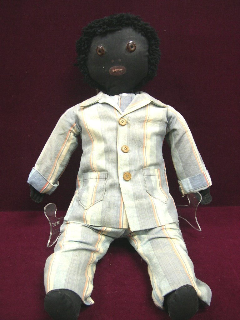 American black cloth Folk Art male doll.: American black cloth Folk Art male doll. Brown button eyes with painted black pupils, painted mouth with teeth and nostrils. All black fabric, Stuffed body, arms and legs. Black wool yarn hair. He 
