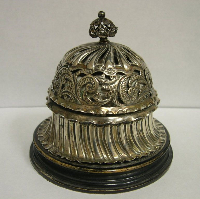 English sterling silver dome form Desk Bell: English sterling silver dome form Desk Bell with openwork, scroll chasing and deep gadroon skirting on circular ebonized wood base. The conforming corona finial twists to chime the bell. Hallmarked Bi