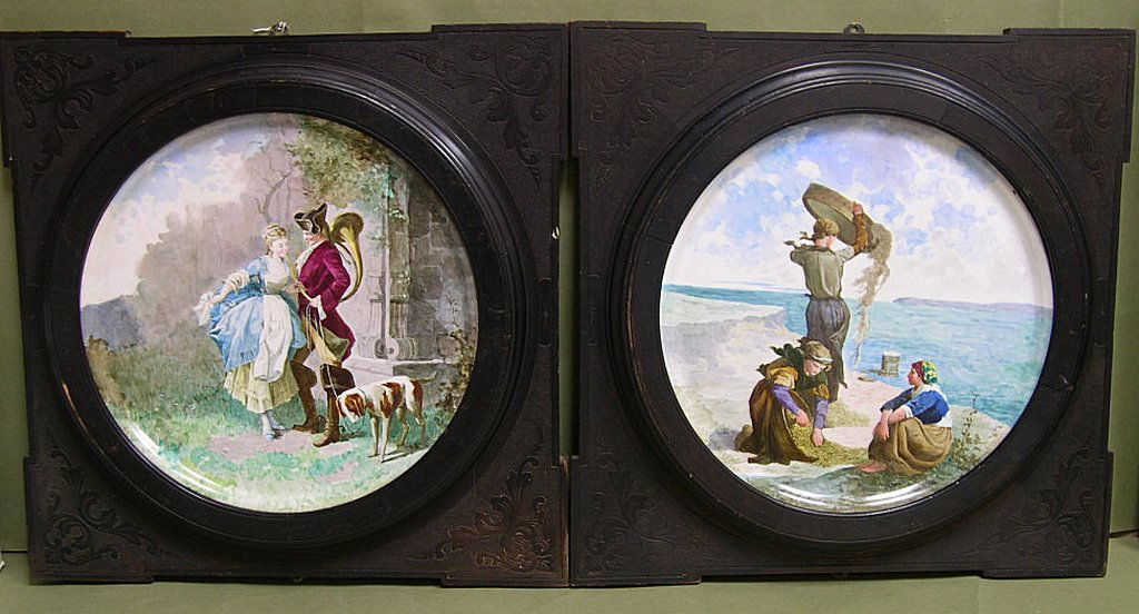 Two French Sarreguemines Utzchneider Plaques: Two French Earthenware Wall Plaques Utzchneider, Sarreguemines, round, painted, one with a scene of three women gathering seaweed by the shore, and the other a romantic scene of a soldier with maiden