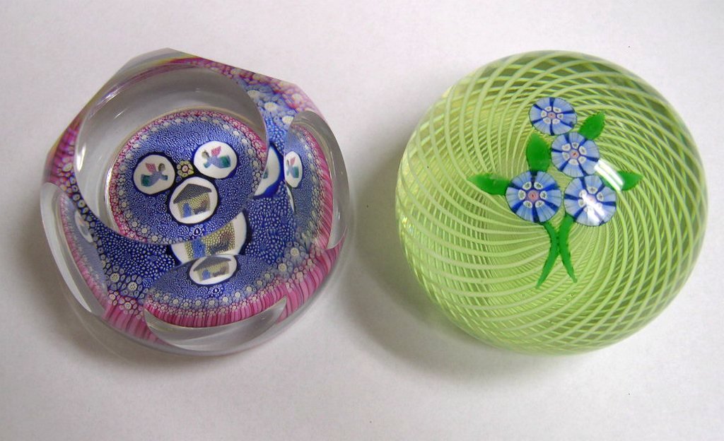 2 Paperweights WHITEFRIARS & PERTHSHIRE: Two artglass paperweights: WHITEFRIARS, England, facetted clear glass over millefiori base, depicting a Nativity scene, Angels over a Manger, dated 1977 #107. Diameter 3 inches; PERTHSHIRE clear glass
