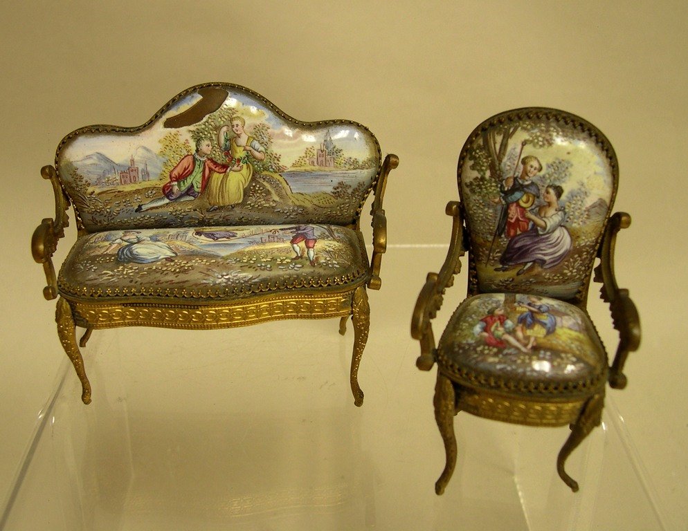 Continental Gilt Metal and Enamel Dolls Furniture: Two (2) pieces of Continental Gilt Metal and Enamel Dolls Furniture comprising of a Rococo style Settee and Armchair. Settee: 2 5/8 x 3 ¼ x 1 ¼ inches; Armchair: 3 7/8 x 1 5/8 x 1 ½ inches