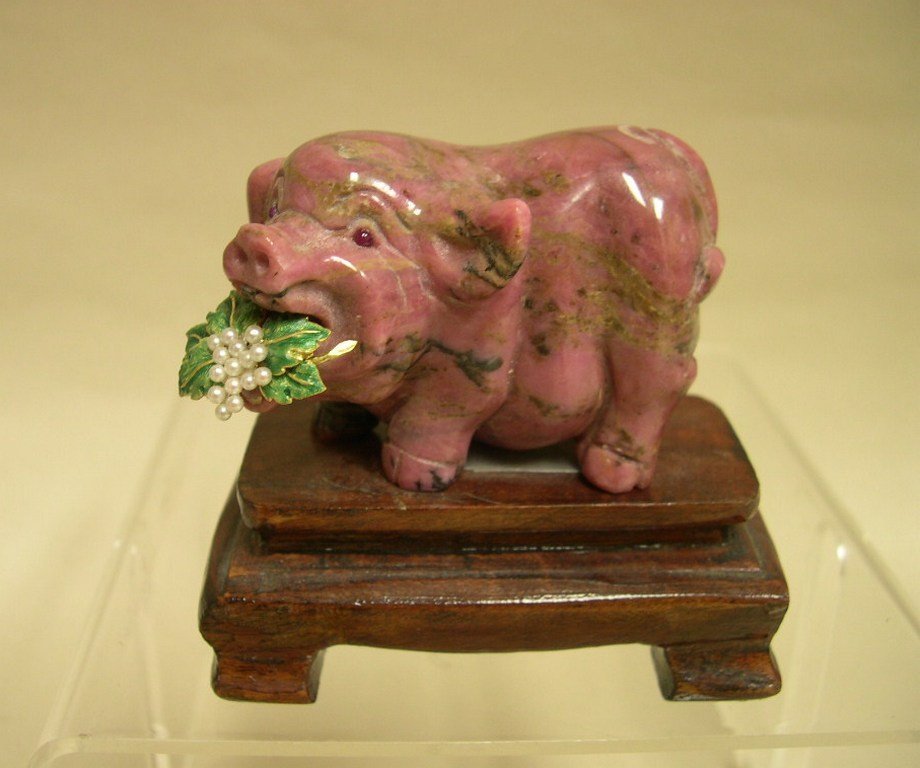 Carved Rhodonite Pig 14K Gold, Enamel, Seed Pearl Leaf: Carved Rhodonite whimsical Pig with inset ruby colored spinel Cabachon inset eyes, holding a 14K yellow gold and enameled leaf with seed pearl spray. Height: 1 1/3 x 2 ¾ x 2 inches approximately Weig