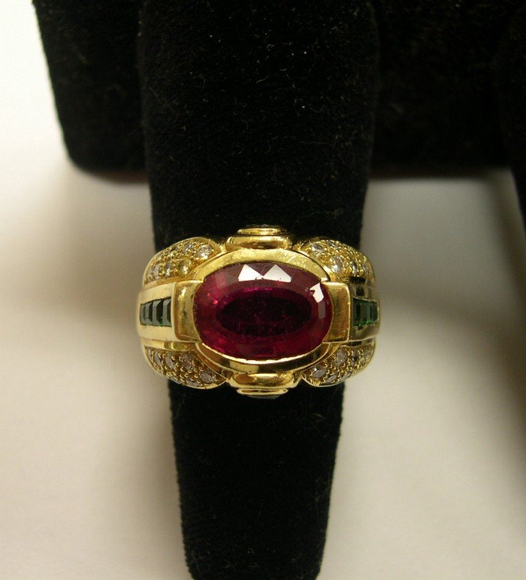 Ladies 18K Gold Ring Pink Tourmaline, & Diamonds: Ladies yellow gold ring centered with an oval mixed-cut pink tourmaline, with what appear to be cabochons and princess cut Tsavorite garnets. with borders of 32 round brilliant cut diamonds. Estimated