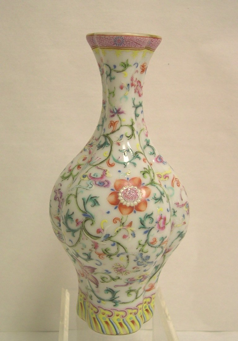 Chinese Famille Rose Enamel Vase: Melon form four lobed body, decorated with eight precious Buddhist patterns, terminating in an ocean wave border.A four red character seal "Qian Long Nian Zhi" on base. Height: 8 1/2 inches.