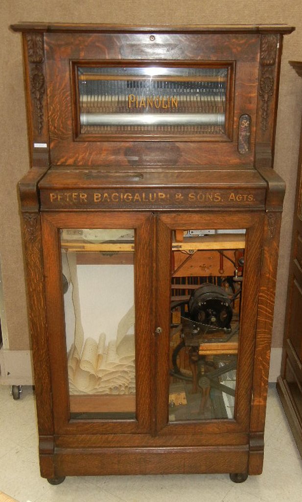 Pianolin - North Tanawanda Musical Instrument Works: Pianolin manufactured by the North Tanawanda Musical Instrument Works, North Tanawanda, New York, circa 1910. Oak case with carved wood applied decorations and double glazed doors. Coin operated 44-no