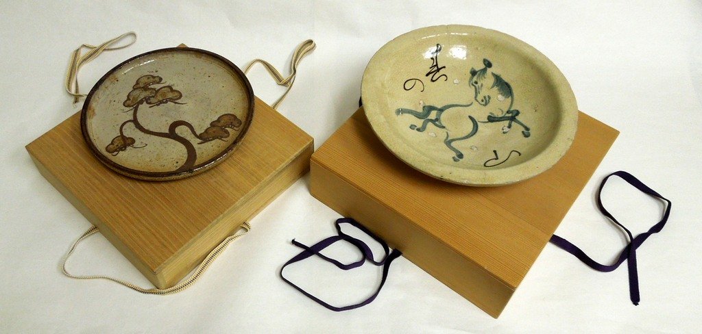 2 Japanese Pottery Plates: Mashiko pottery plate with pine decoration, Diameter: 9 1/4 inches, with kiri wood box. Together with a studio pottery dish made for the Year of the Horse, Diameter: 10 3/4 inches, with kiri wood box.