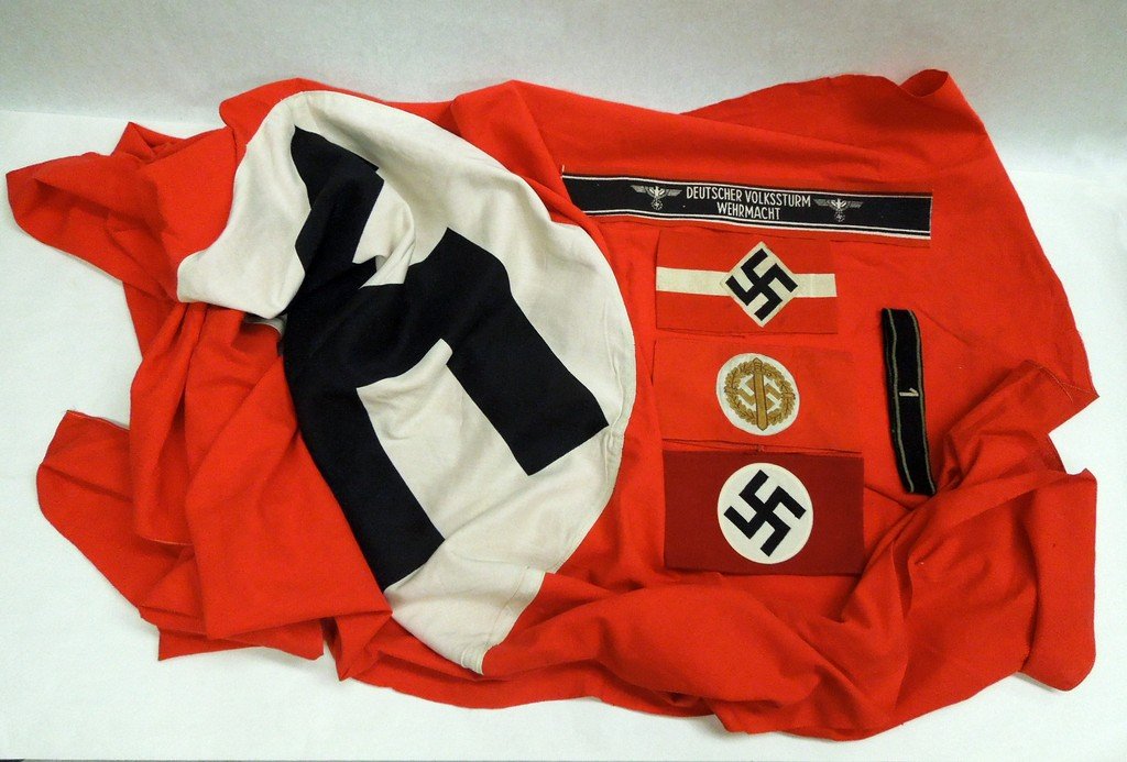 Collection of German WW2 fabric items: Collection of German WW2 fabric items. Includes a German WW2 flag, approximately 77 x 45 inches, insignia 29 inch diameter; an SA armband with an RZM tag, an SA Sports armband with a partial tag, a Hi