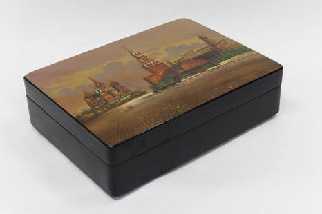 Russian Fedoskino Lacquer Box.: Russian hinged and footed rectangular lacquer box with red interior. Miniature painting depicts the city of Moscow including the Moscow Kremlin and Saint Basil’s Cathedral set against an iridescent