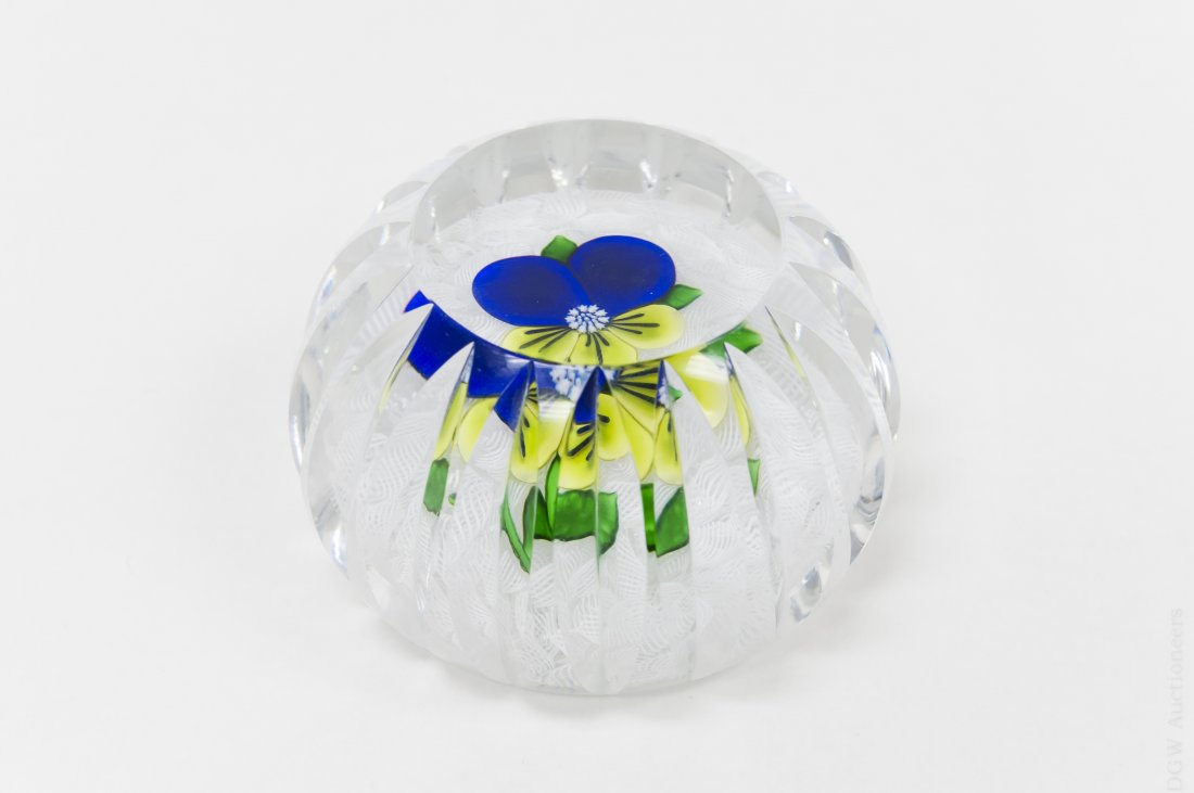 Cristal Saint-Louis Art Glass Paperweight.: Faceted Cristal Saint-Louis art glass paperweight. White lace base with blue and yellow pansy in center. Marked SL 1980. (Approx. 2" x 2 1/2"). From the Collection of Eric Sinizer and the Light Opera 