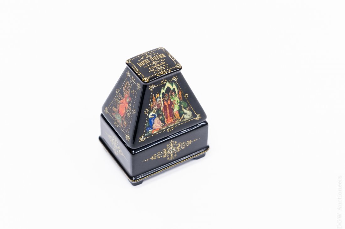 Russian Palekh Lacquer Box.: Russian Palekh hinged and footed lacquer box with a pyramid lid. Miniature paintings on the four sides of the lid depict courtly scenes with gold foliate accents. Top is signed and inside is inscribed