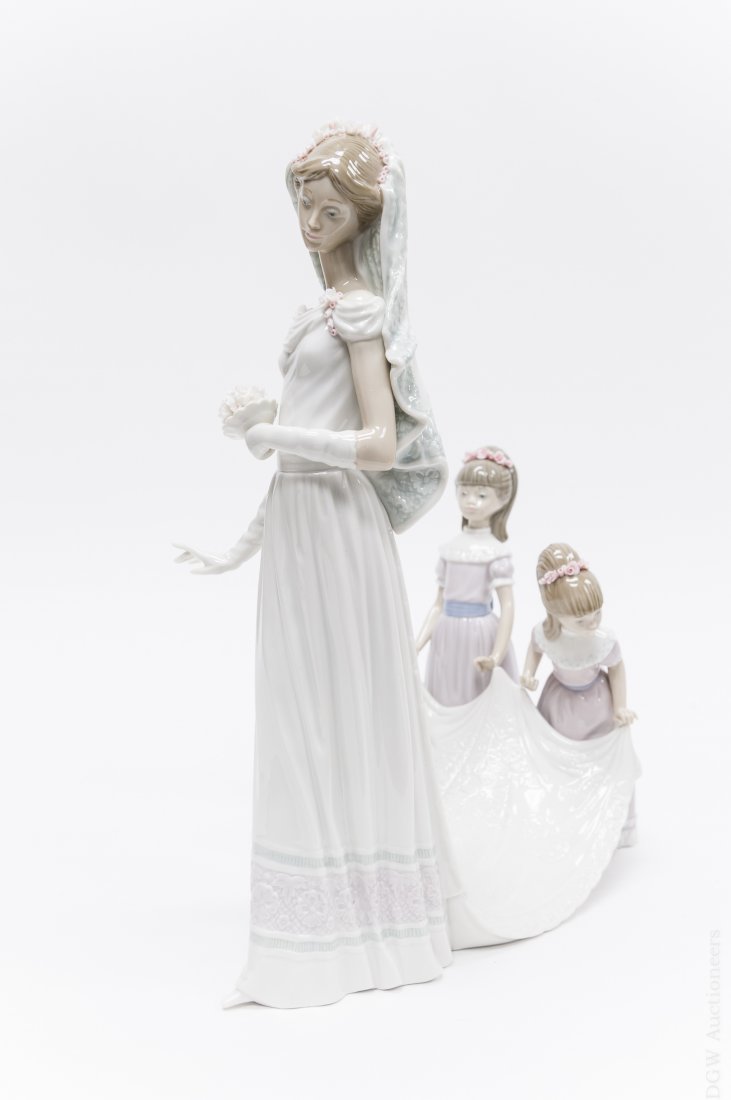 Lladro Porcelain Group, Here Comes the Bride.: Lladro porcelain figural group, Here Comes the Bride (no. 1446). Sculptor: José Puche. (Approx. 15" x 13"). With Lladro box.
