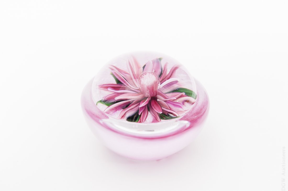 Ayotte Art Glass Paperweight.: Melissa Ayotte art glass paperweight. Modeled pink paperweight with clear domed top depicting a single pink chrysanthemum. Etched M. Ayotte 2006. (Approx. 3" x 2"). From the collection of Eric Sinizer
