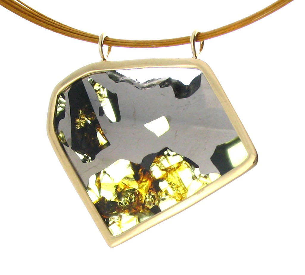ESQUEL PALLASITE WITH NATURAL SURFACE EDGE: Measures: 1.2" Wide x 1.1" Tall - Metal: 14kt Gold Frame - Stone: Esquel Meteorite - This shield shaped Esquel meteorite section comes from a pallasite meteorite that fell in Argentina in 1951. Weighi