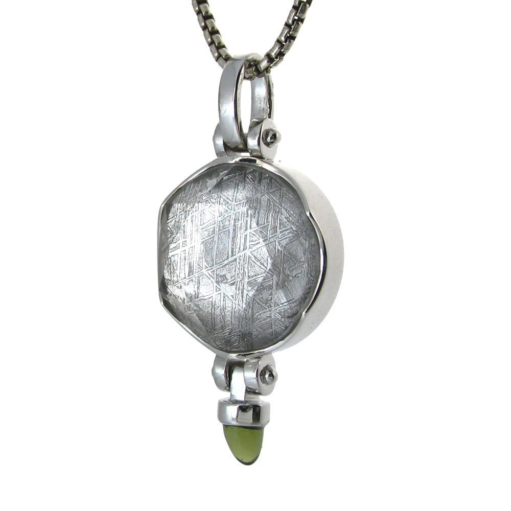 GIBEON METEORITE ACCENTED WITH MOLDOVITE: Measures: 1.5" Tall x .75" Wide - Metal: Sterling Silver - Stone: Gibeon Meteorite - Moldovite - Custom designed pendant featuring both a Gibeon meteorite and a dangle cabachon of Bohemian moldovite t