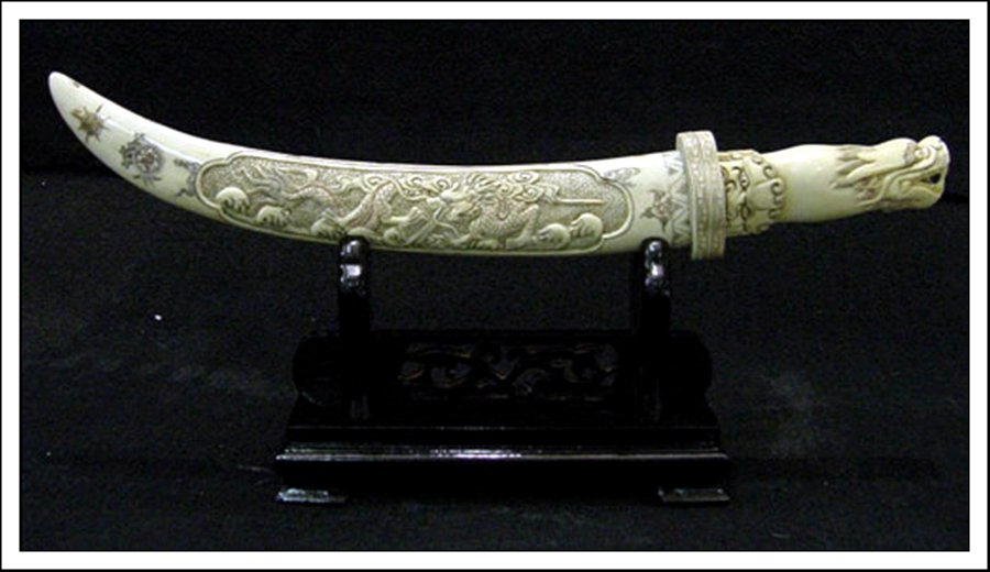 ANTIQUE BONE DRAGON SWORD SET: Antique Bone Dragon Sword Set - This Sword Set Is Made Of Bone. It Has Been Specially Stained And Painted. There Is A Dragon Carved In The Front. It Sits On A Rosewood Stand. The Sword Blade Is Also M
