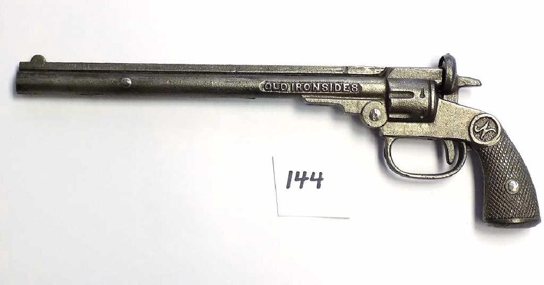 NATIONAL OLD IRONSIDES CAST IRON COWBOY CAP GUN: National Old Ironside Cast Iron Cowboy Cap gun pistol. Circa 1922. Long barrel 10 1/2". Working order, Nice condition, nice patina.