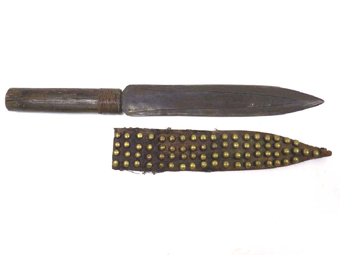 TRIBAL BOWIE KNIFE WITH SHEATH: 19th Century Tribal Bowie Knife with Brass Riveted Leather Sheath. Old Wood Handle with Wrapped Wire. Patinized Steel Blade with Blood Grooves. Length 16 3/4"