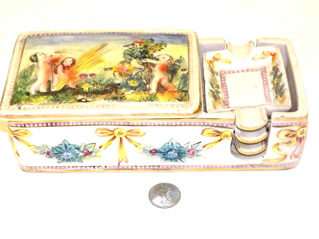 CAPODIMONTE CIGARETTE BOX W/ ASH TRAYS: Rare Capodimonte Cigarette / Tobacco Box with Set of Ashtrays. Decorated with Nude Figures and Surrounding Wreathed Ribbons. 2.50" x 3 3/4" x 8.50"