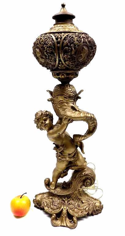 RENAISSANCE REVIVAL GILT BRONZED PARLOR LAMP: 19th Century Renaissance Revival Gilt Bronzed Iron Parlor Lamp. Sculpted Putti Holding a Cornucopia. Ornate Openwork Top with Floral Decoration and Center Medallion Head. Fancy Original Lid with Scrol