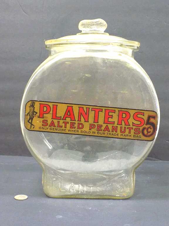 1940'S PLANTERS PEANUTS STORE DISPLAY GLASS JAR: Vintage 1940's Planters Peanuts Glass Counter Display Jar. 5 Cents Advertising Label with Mr. Peanut. Original Peanut Handle Lid. Height 13" x Length 9.50"