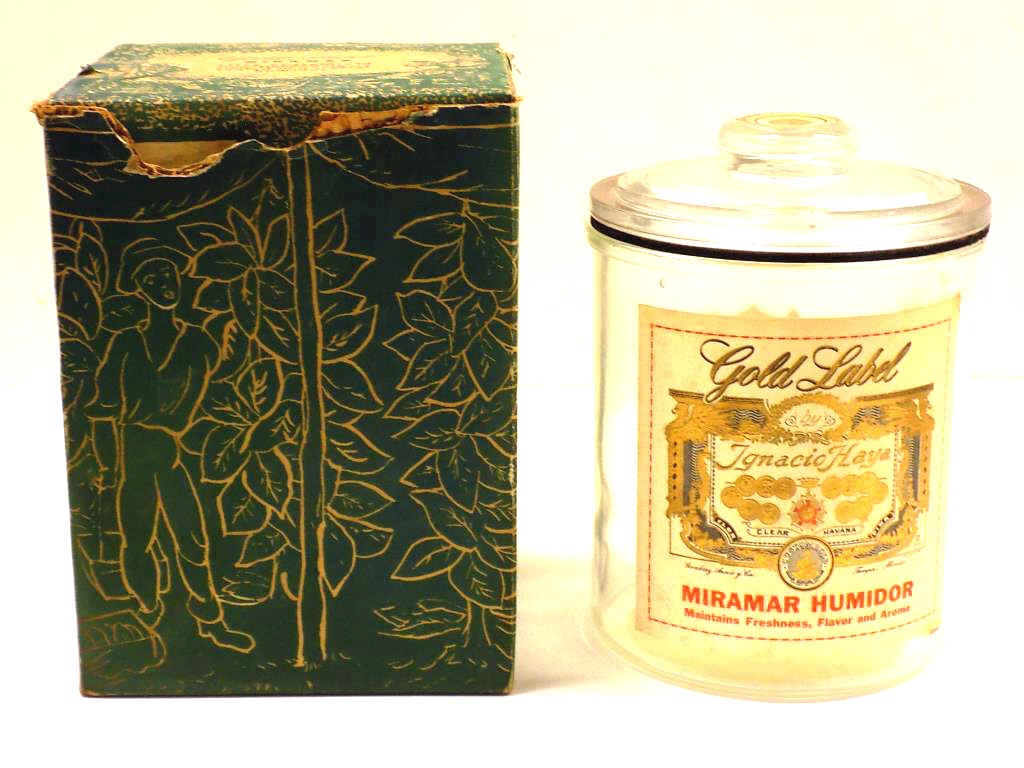 VINTAGE GOLD LABEL GLASS CIGAR LIDDED HUMIDOR: Vintage Gold Label Ignacio Haya Clear Havana Cigar Miramar Humidor. Glass with Original Advertising Labels and Cardboard Box. Height 8.50"