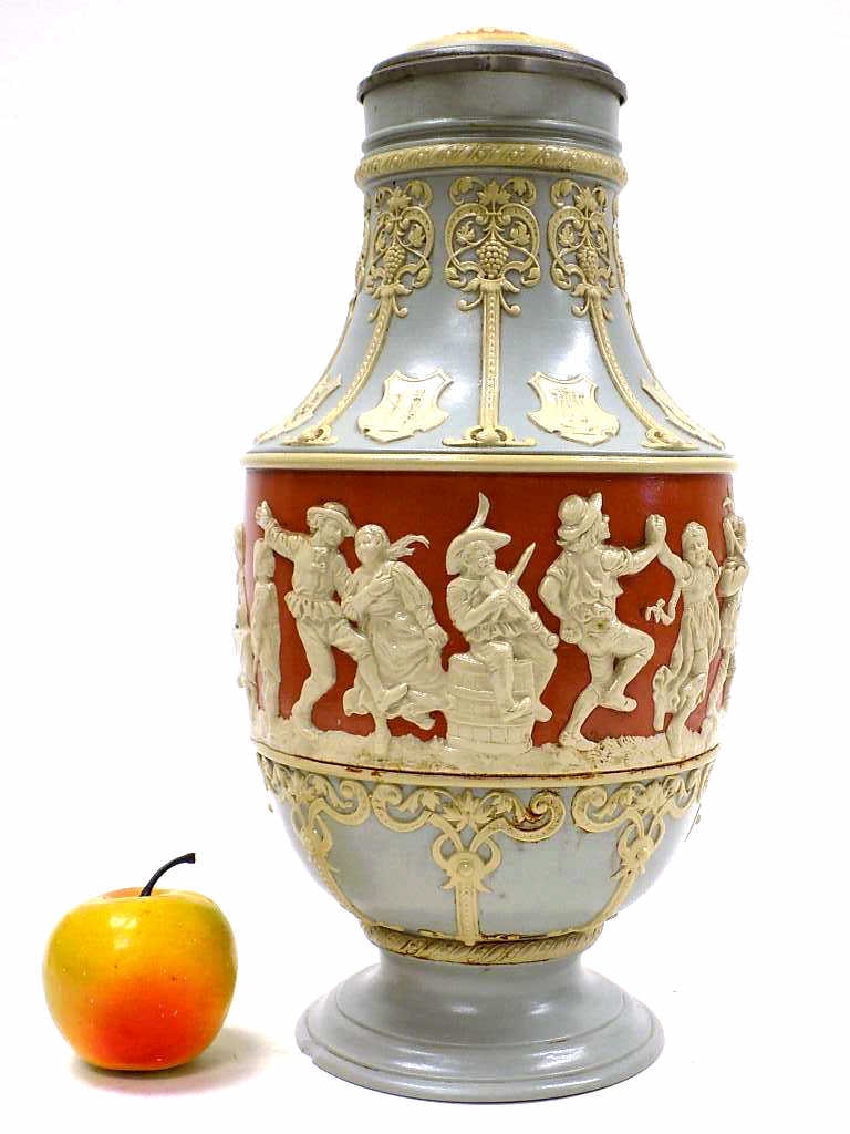 BIG METTLACH PEASANT DANCE BEER STEIN No 2085: Big Mettlach Pottery Beer Stein No 2085. Entitled Peasant Dance. Surrounding Relief Decoration with Celebrating Figures, Symbolic Shield Cartouches and Grape Vines.Terra Cotta Ground. Fancy Pewter Thu
