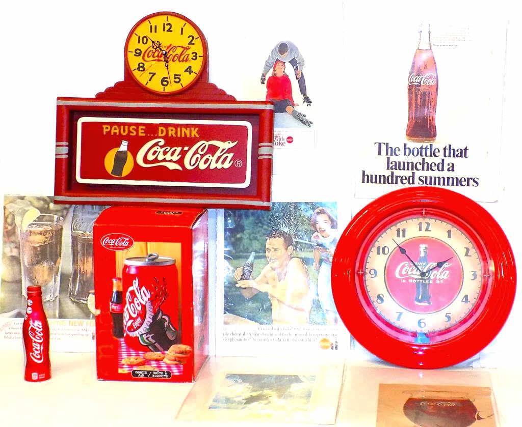 COCA COLA COLLECTIBLE CLOCKS COOKIE JAR ADS: Assorted Coca Cola Collectible Lot. Including 2 Logo Clocks (working order) Boxed Soda Can Cookie Jar (repaired lid) and 6 Vintage Ads. Clock Measurements: 15.50" x 17.50" and Round Clock 15" Diameter