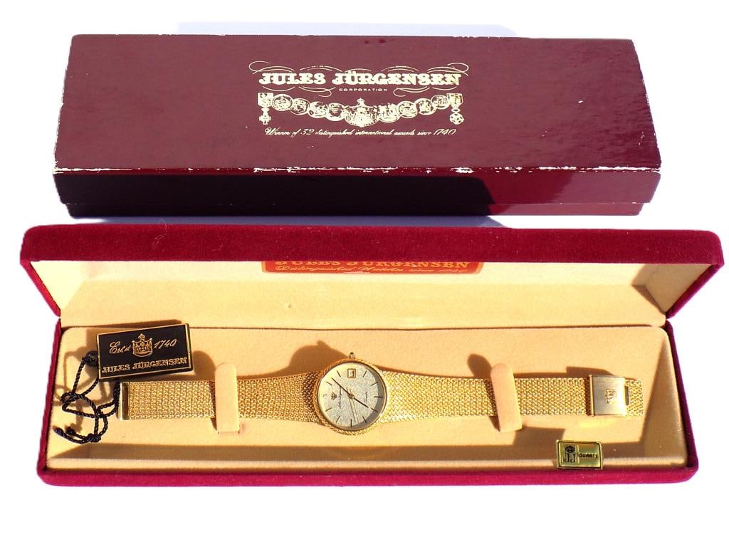 JULES JURGENSEN GOLD TONE MEN'S WRISTWATCH: Vintage Jules Jurgensen Gold Tone Men's Wristwatch. Quartz Movement with Diamond Chip Face & Date Display. Adjustable Bracelet. With Original Boxes, Tag & Papers. Length 8.50" Excellent condition, nee