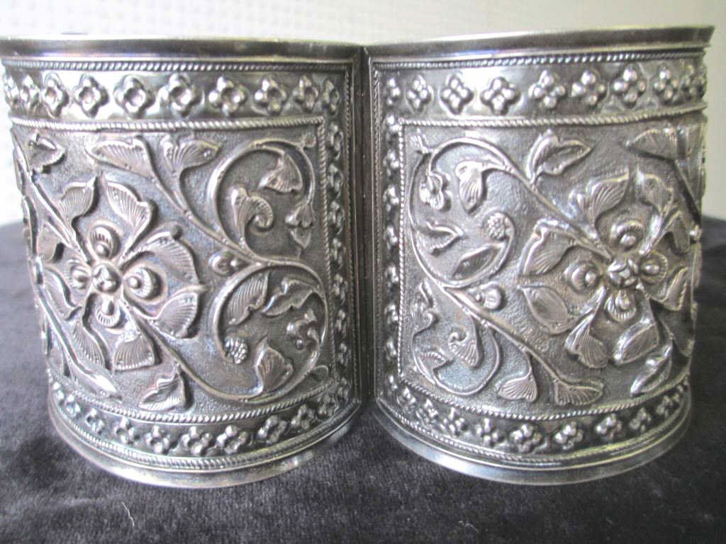 VINTAGE PERSIAN SILVER REPOUSSE BRACELET: Vintage Persian Silver repousse cuff bracelet . Floral design with ropetwist borders & rosettes . Locking open / close hinge. Signed H.T. with persian marks. H & D 2.50" . 2.25 Troy Oz
