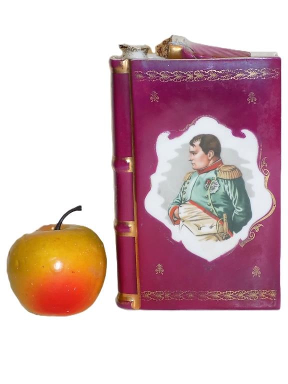 LIMOGES NAPOLEON PORCELAIN BOOK FLASK: Antique Limoges Napoleon Book Form Porcelain Flask. Cognac Titled Spine. Feather Form Stopper Present but repaired. Height 7" x Width 1.5" x 4.5" Length 1 lb