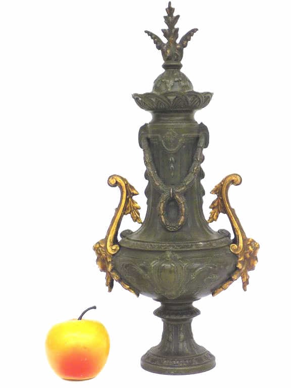 NEOCLASSICAL GILT BRONZED PUTTI URN SCULPTURE: Neoclassical Gilt Bronzed Metal Urn Sculpture. Featuring Dual Putti Mask Handles with Scrolled Acanthus. Draped Bellflower Wreath Motifs. Height 15.50" x Width 6" x Length 7.5" x 4 lbs
