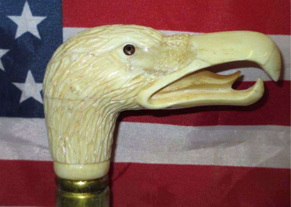 AMERICAN EAGLE CARVED BONE CANE: American eagle head carved bone cane / walking stick . Brass & Mahogany mounts. L 35". Handle 4"