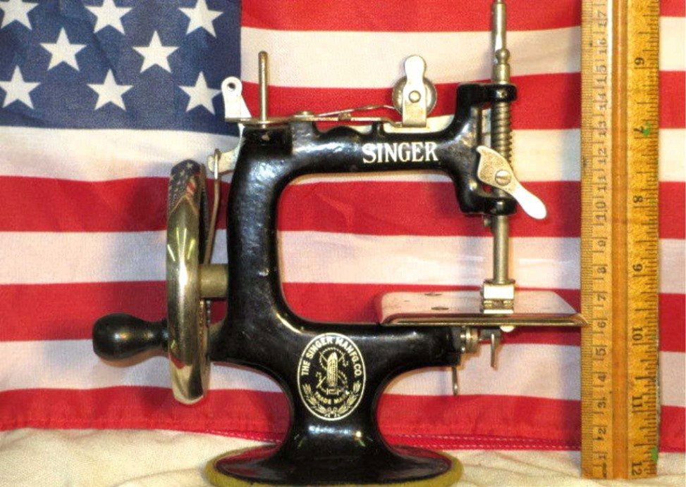 MINIATURE SINGER SEWING MACHINE: Singer Manufacturing Company miniature sewing machine. Original Chrome & gilt enameled iron frame. H 6.50". Fine working order.