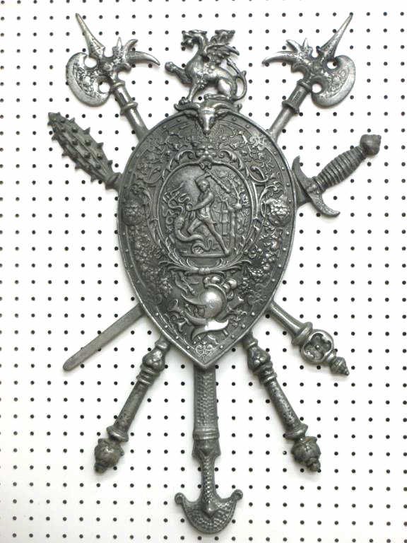 MYTHOLOGICAL WARRIOR WEAPONS SHIELD: Mythological silver metal scenic shield plaque . Surrounding lion heads , battle ram, knight & foilage with Percious slaying Medusa in center. Griffin crest with swords , battle club & halliburtons. H
