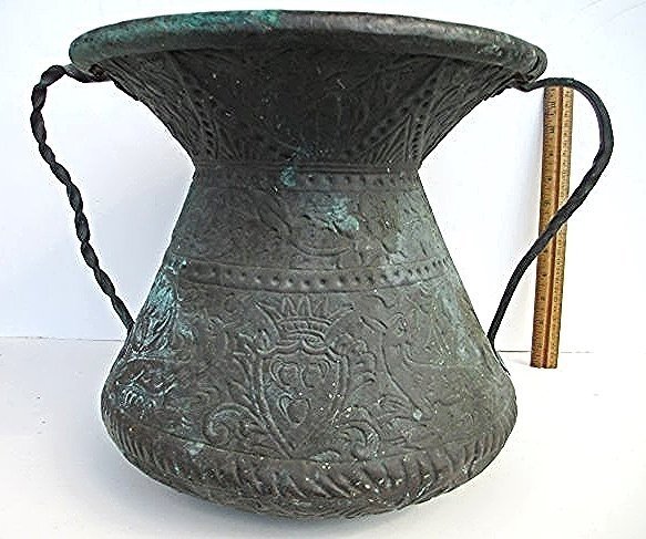 19TH CENTURY PERSIAN COPPER VESSEL: 19th Century Persian repouse copper vessel . Hand wrought turned handles. Crowned shield crest with creatures surrounded with floral motifs & scroll work . H 12" x 16.50".