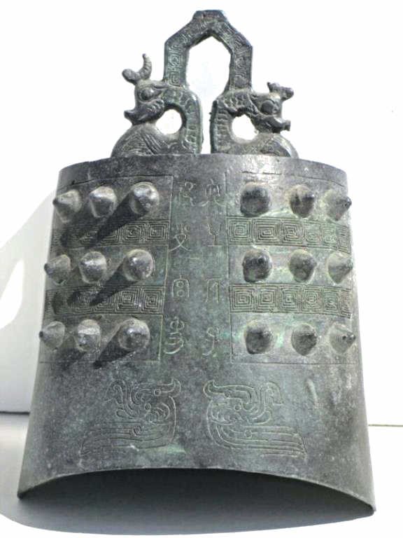 CHINESE ZHOU FORM BRONZE TEMPLE BELL: Chinese Zhou form bronze temple bell . Serpents handle with spikes . Inscribed on each side . Vertigo patina. H 8 1/2".