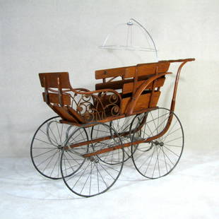 19th Century Wicker Baby Carriage: Gorgeous antique baby pram, crafted by the Gendron Wheel Company. Hardwood with wicker detailing. In excellent condition. Brake is functional. The parasol piece was replaced long ago and was crafted a