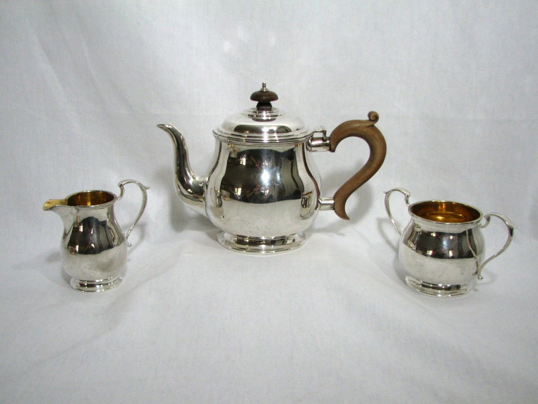 Antique Sterling English Teapot, Sugar & Creamer: Full set of antique sterling silver tea service. Teapot with hardwood handle, sugar & creamer. Gold wash on the inside of the sugar and creamer. In very good condition. English hallmarks on the side o