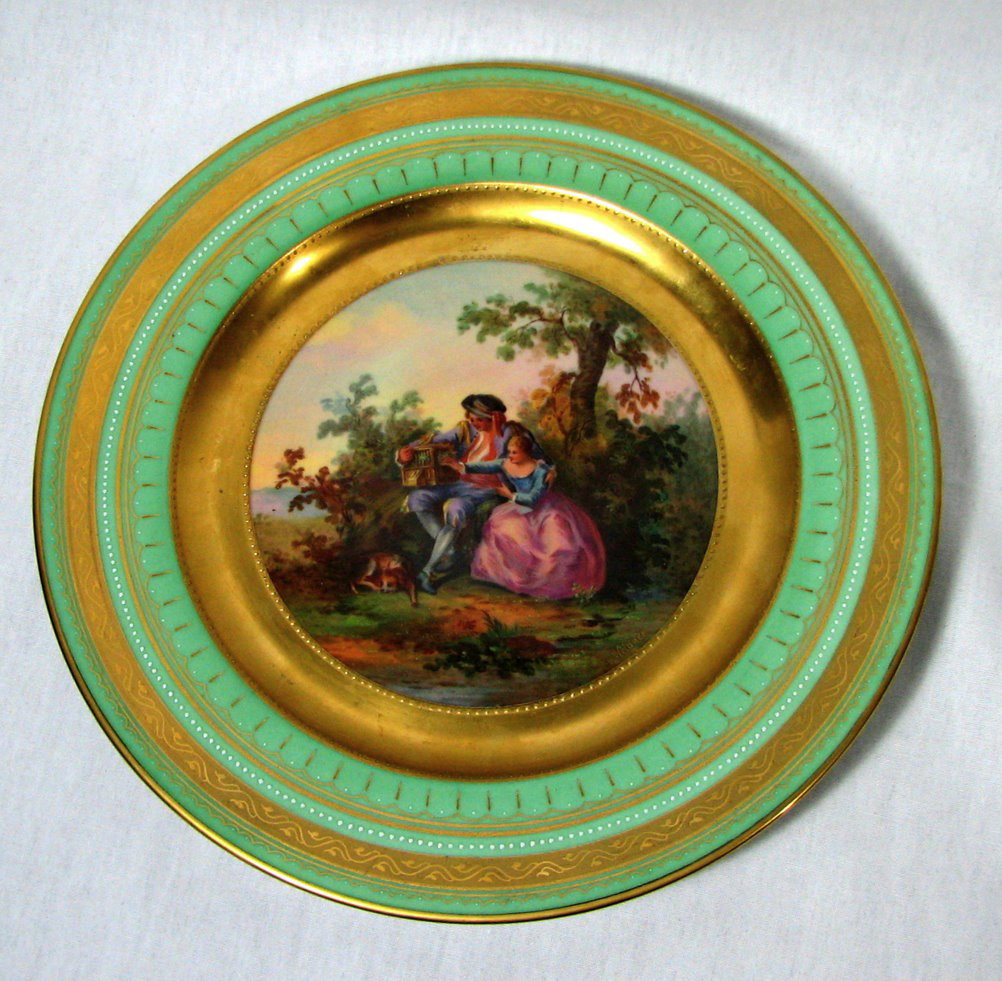 Antique Plate in Style of Royal Vienna: An antique dinner plate in the style of an earlier 18th Century Royal Vienna Du Paquier plate, The Bird Catcher. Hand- painted with gold edging. Signed: K. Wilner. Marked on the back: The Bird Catcher