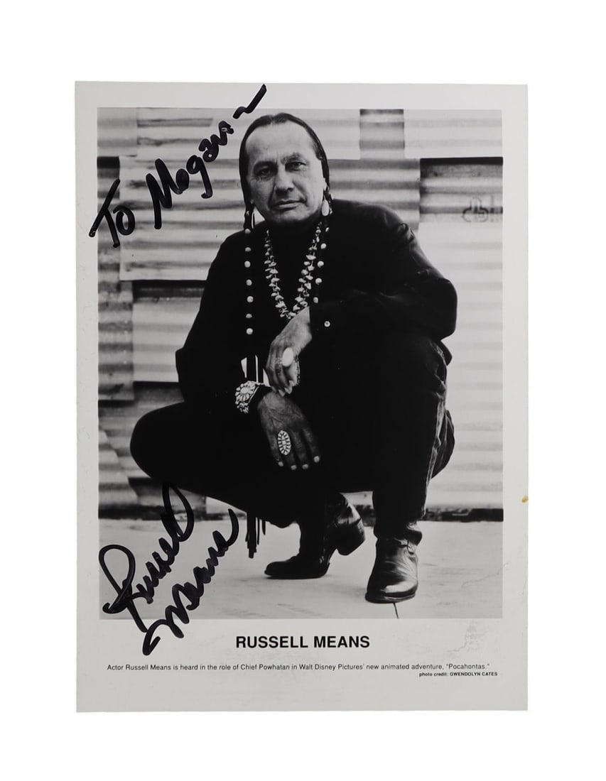 RUSSELL MEANS SIGNED INSCRIBED PRESS PHOTOGRAPH OGLALA LAKOTA ACTIVIST AND AMERICAN INDIAN MOVEMENT: Russell Means was the most publicly visible leader of the American Indian Movement during its most confrontational years, the organizer of the 1972 Trail of Broken Treaties march on Washington and a c