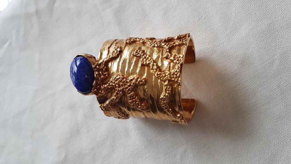 YVES SAINT LAURENT par Stefano Pilati Bracelet: YVES SAINT LAURENT par Stefano Pilati Bracelet manchette en métal doré ciselé, cabochon bleu Bon état
