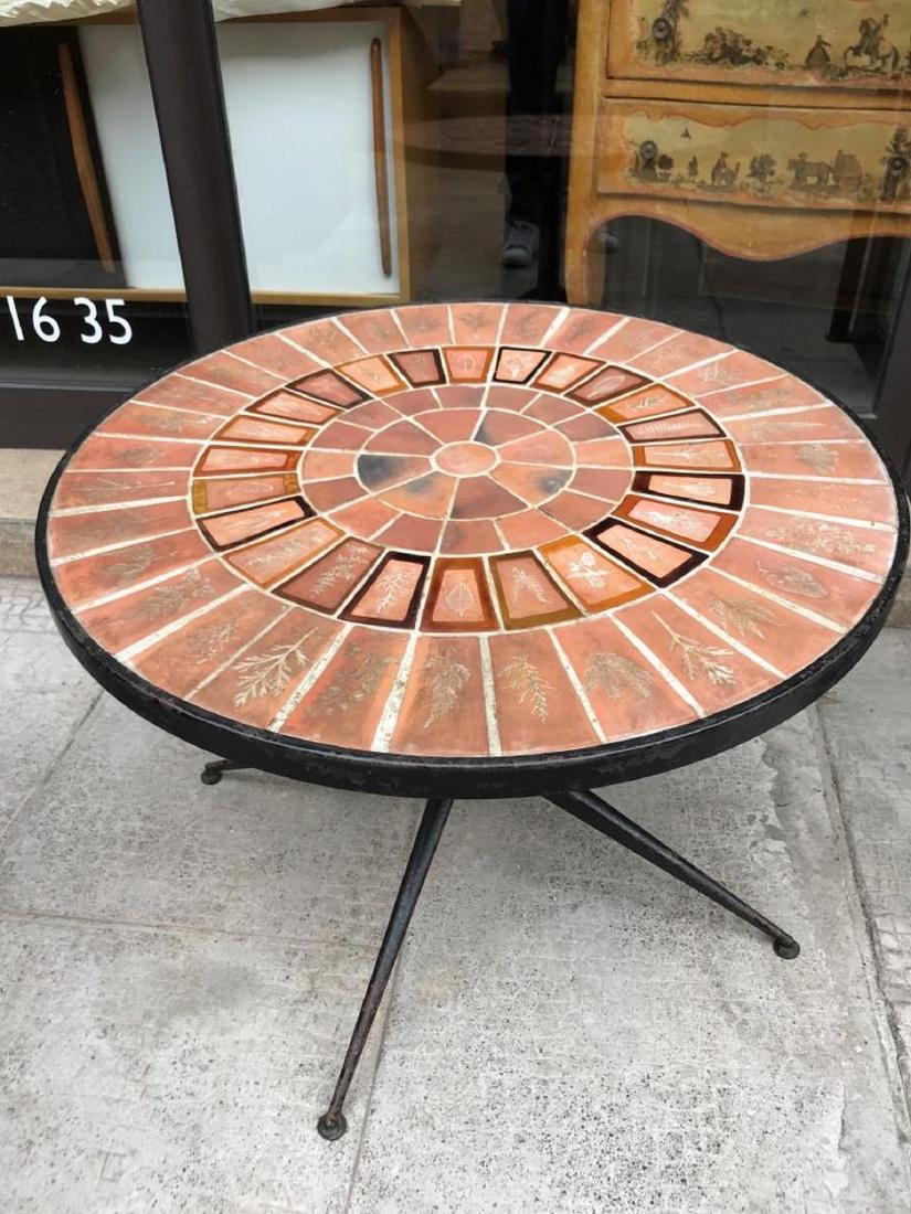 Roger CAPRON (1922-2006) Table basse circulaire avec: Roger CAPRON (1922-2006) Table basse circulaire avec plateau composé de carreaux de céramique, piètement en métal laqué noir 54 x 72 cm