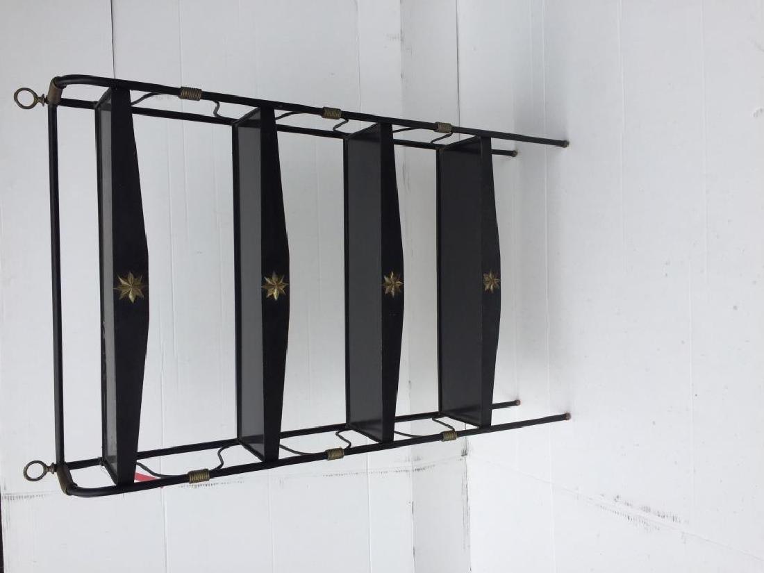 Jacques ADNET, vers 1955 Etagère à quatre: Jacques ADNET, vers 1955 Etagère à quatre niveaux composée de tablettes en mélaminé et opaline noire sur quatre pieds tubulaires laqués noir à décor d'enrouleme