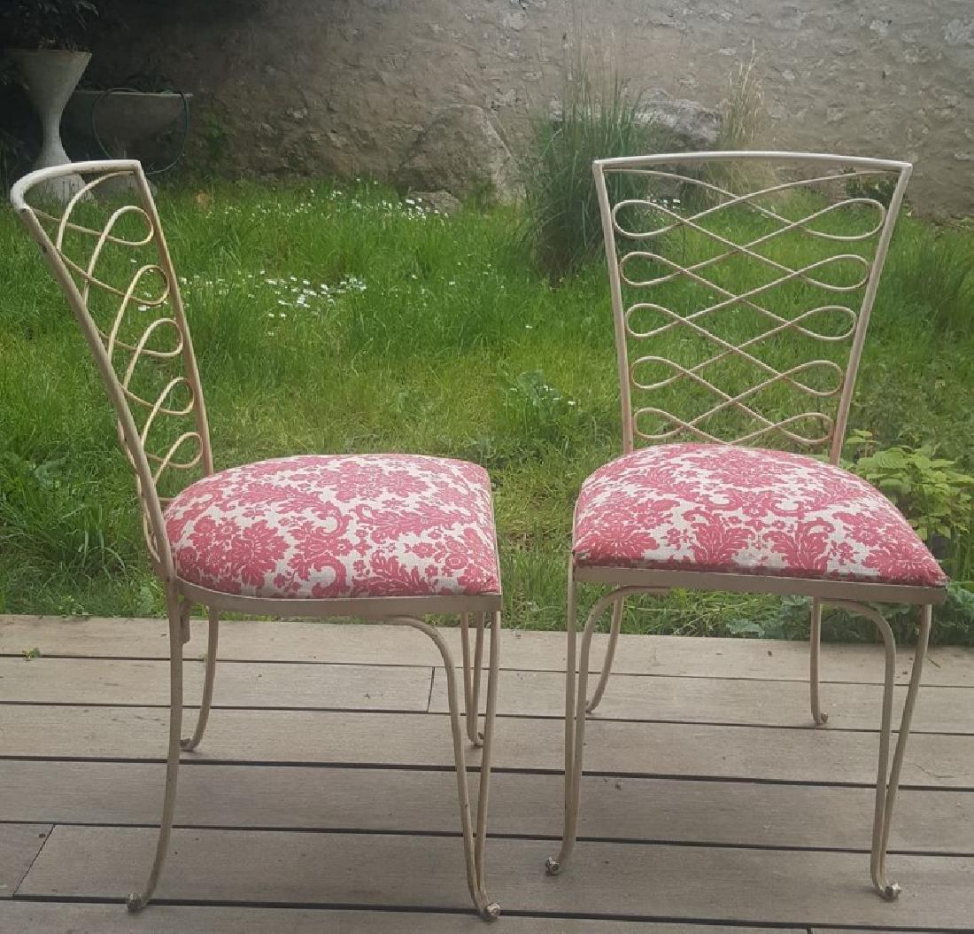 René Prou, vers 1940 Paire de chaises en fer: René Prou, vers 1940 Paire de chaises en fer laqué crème à assises en tissu fleuri disposées sur des structures à décor de volutes et reposant sur quatre pieds à