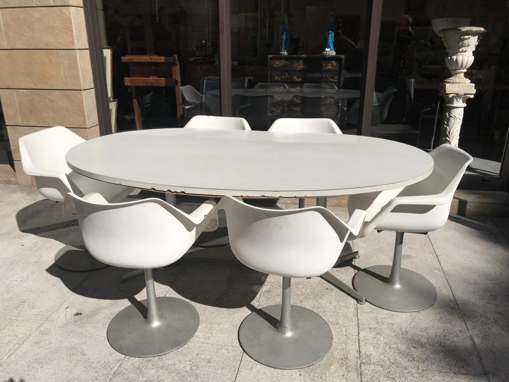 Robin DAY - HILLE Edition Suite de six fauteuils à: Robin DAY - HILLE Edition Suite de six fauteuils à coque en ABS blanc et piètement en métal relaqué gris On y joint une table de salle à manger ovale à plateau en mé