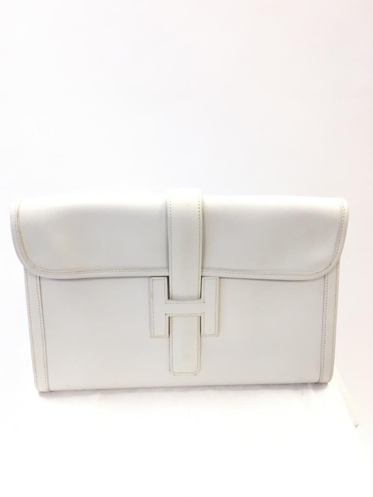 HERMES Pochette modèle « Jige » en cuir blanc Dans sa: HERMES Pochette modèle « Jige » en cuir blanc Dans sa boîte avec son dustbag 19 x 29 cm