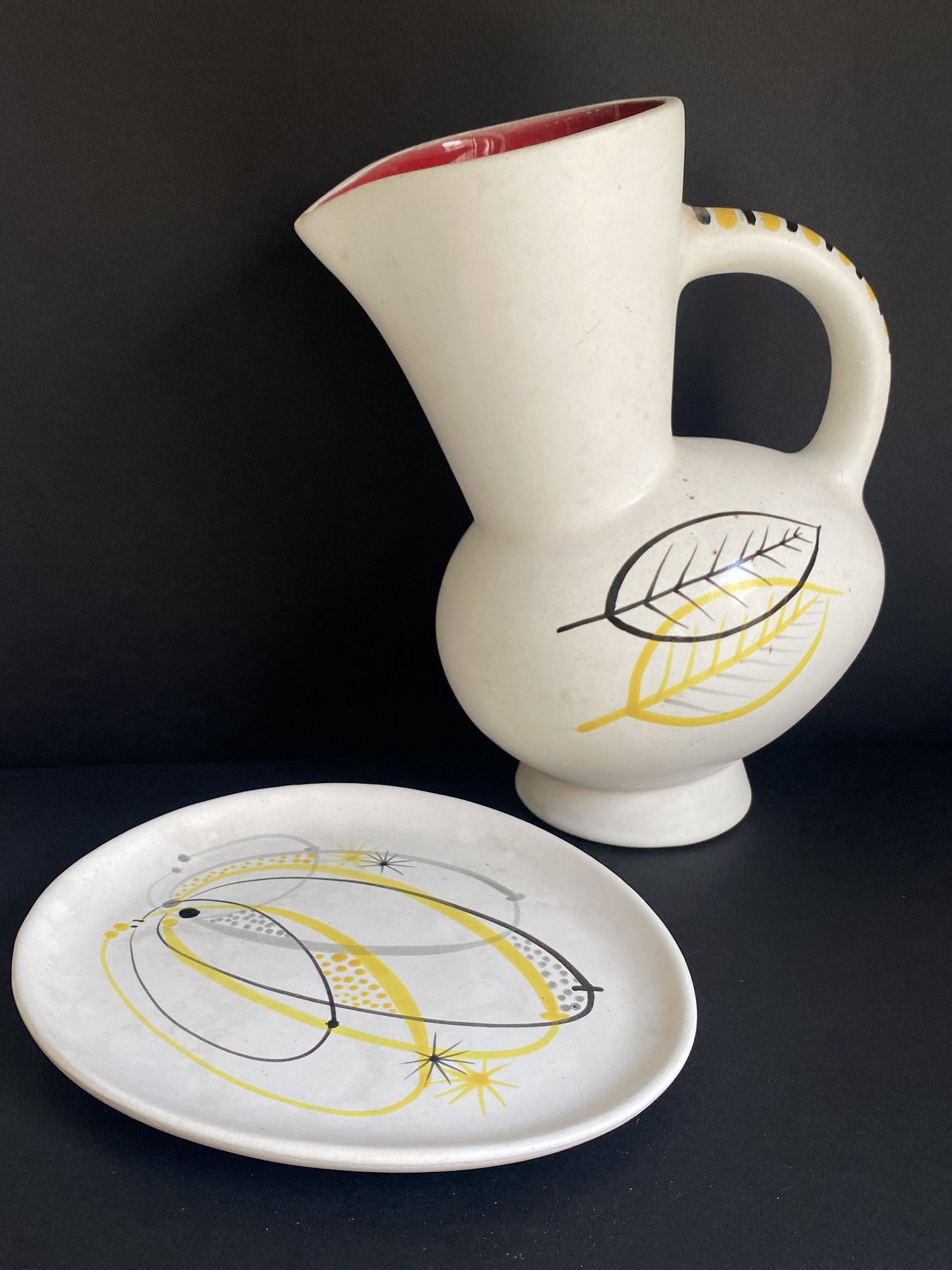 André BAUD (1903-1986) Ensemble de deux pièces comprenant un pichet et une coupelle en: André BAUD (1903-1986) Ensemble de deux pièces comprenant un pichet et une coupelle en faïence émaillé blanc à décor stylisé à émail jaune et noir Mar
