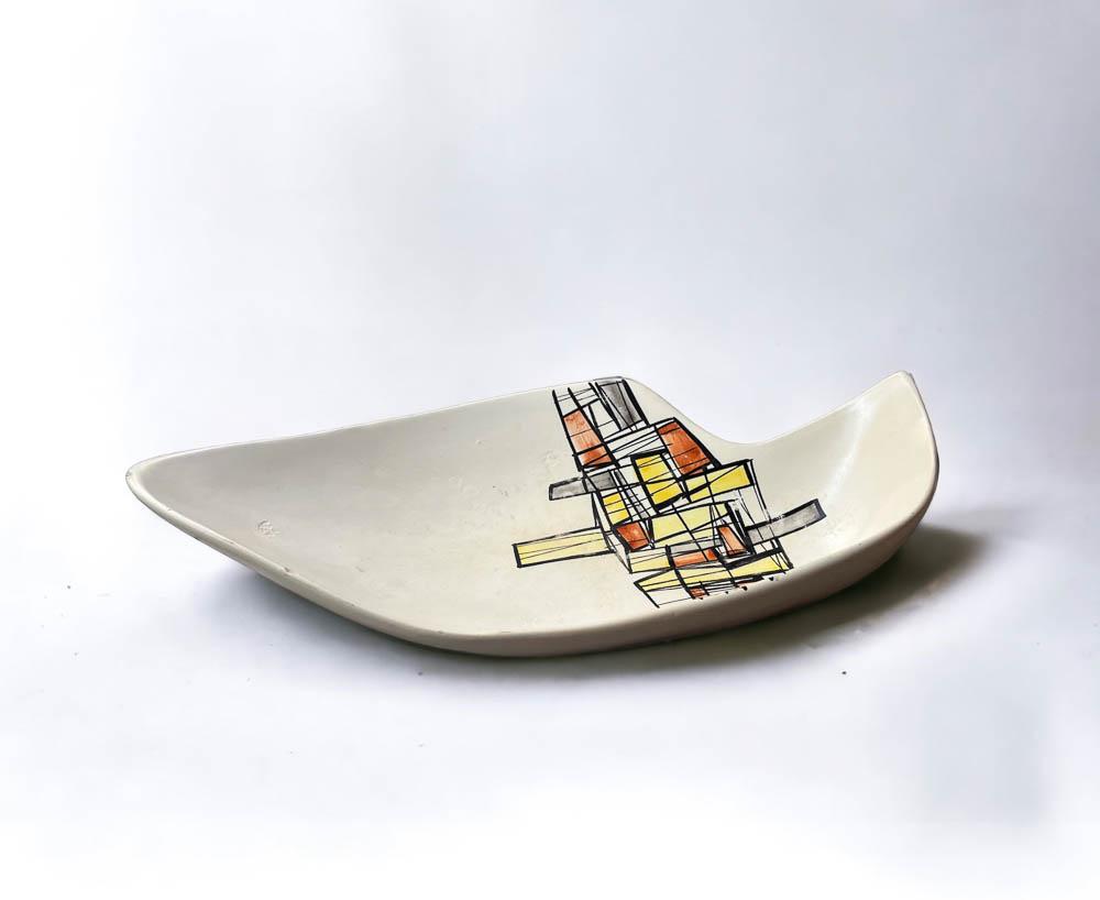CAPRON - PLAT EN TERRE BLANCHE ÉMAILLÉE: Roger CAPRON (1922-2006) Grand plat en terre blanche émaillée à décor de motifs géométriques colorés Signé dessous 48 x 26 x 10 cm (Egrenures et manques)